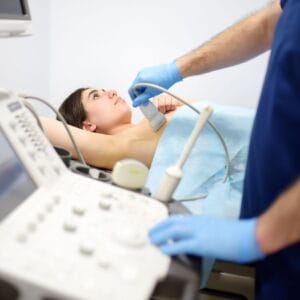 Zdjęcie przedstawiające lekarza przeprowadzającego USG piersi.