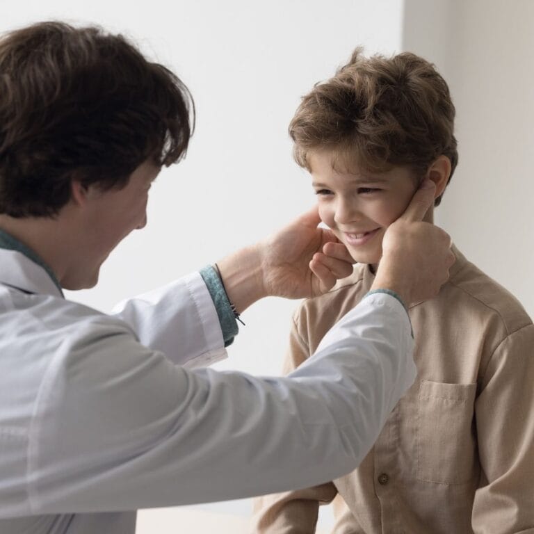 Zdjęcie przedstawia lekarza wykonującego badanie palpacyjne węzłów chłonnych.