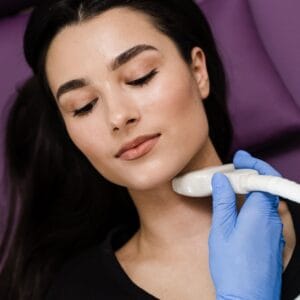 Zdjęcie przedstawia lekarza endokrynologa wykonującego badanie USG tarczycy.