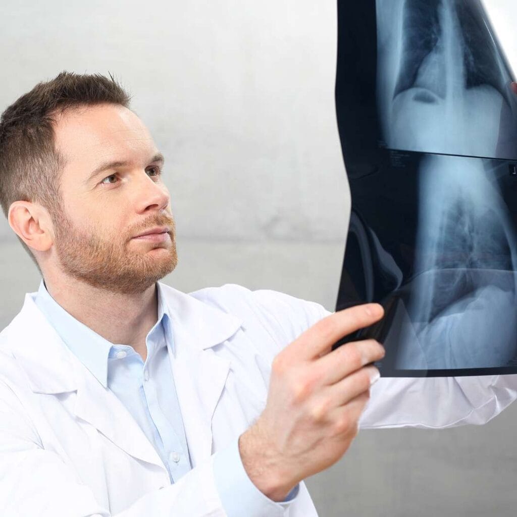 Zdjęcie przedstawia ortopedę analizującego prześwietlenie RTG podczas konsultacji ortopedycznej.