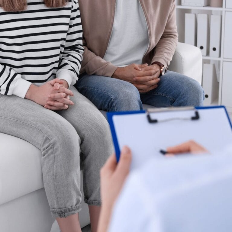 Grafika przedstawia lekarza wenertologa udzielającego konsultacji parze pacjentów.